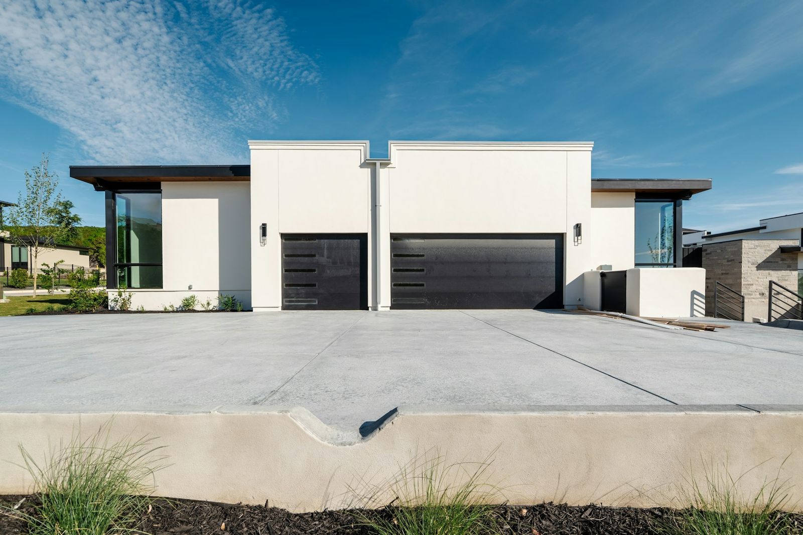 Freshly poured concrete driveway in front of a modern home